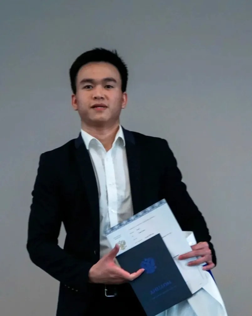スーツ姿でバウマン・モスクワ国立工科大学の卒業証書を持つTim Nguyen（2022年）